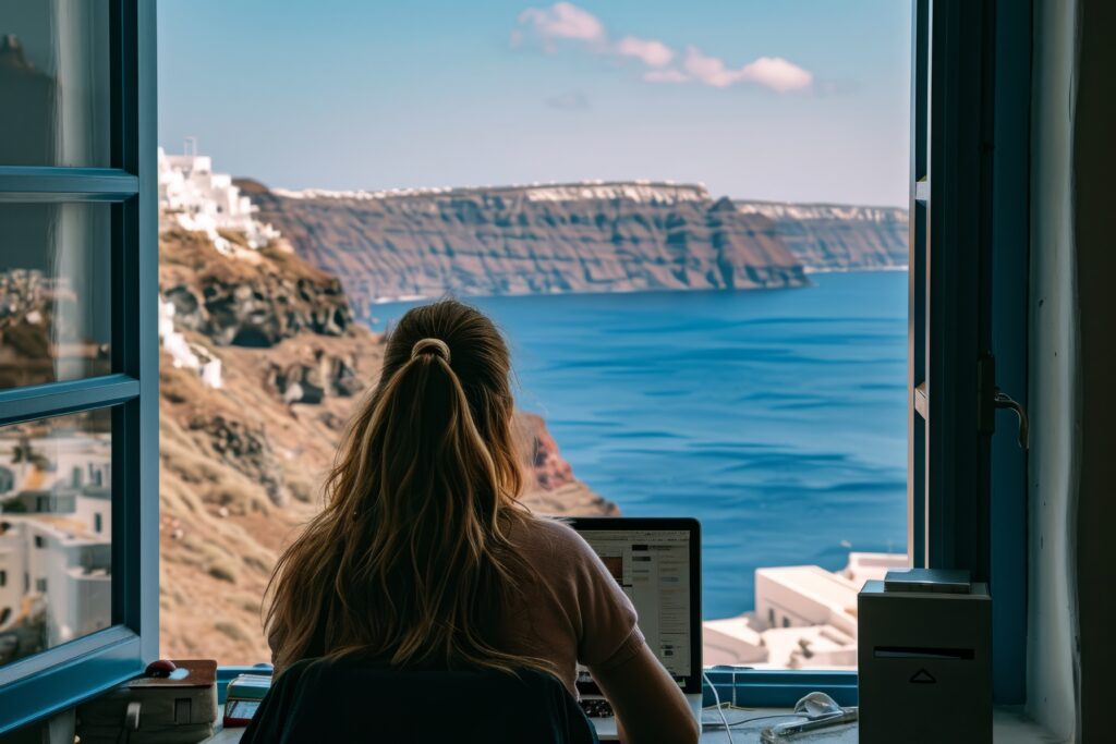a woman sitting at a desk looking at a large body of water